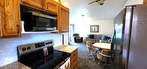 Kitchen featuring light stone counters, stainless steel appliances.