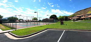 View of sport court with a residential view, fence, and a yard