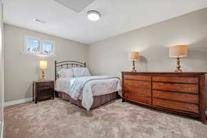 Bedroom featuring light carpet, visible vents, and baseboards