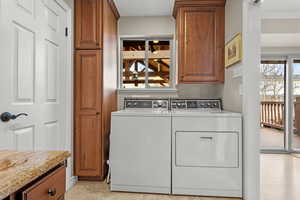 Washroom featuring separate washer and dryer and cabinet space