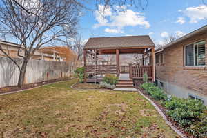 View of yard with a deck and fence