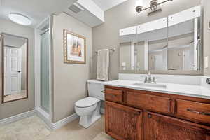 Bathroom featuring visible vents, toilet, vanity, a shower stall, and tile patterned flooring