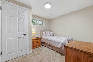 Bedroom featuring light colored carpet and visible vents