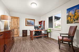 Office area with wood finished floors, visible vents, and baseboards