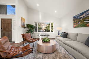 Living area featuring baseboards, high vaulted ceiling, wood finished floors, and recessed lighting