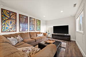 Living area with recessed lighting, visible vents, dark wood finished floors, and baseboards