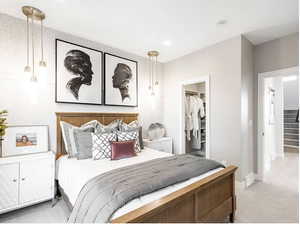 Bedroom featuring a closet, light carpet, a spacious closet, and baseboards