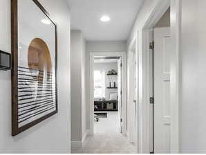 Hallway featuring baseboards and light colored carpet