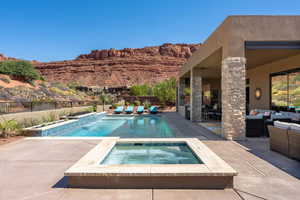 View of swimming pool with a fenced in pool, an in ground hot tub, fence, a patio area, and an outdoor living space with a fireplace