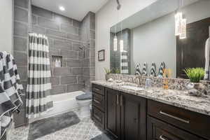 Bathroom with shower / bath combination with curtain, vanity, and toilet