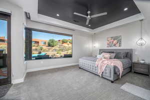 Bedroom with carpet floors, baseboards, a tray ceiling, and recessed lighting