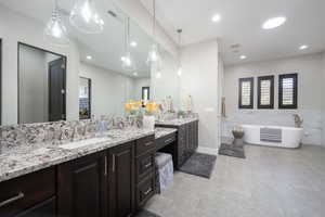 Full bathroom with recessed lighting, visible vents, a freestanding bath, vanity, and tile patterned floors