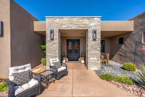 Doorway to property featuring stone siding, french doors, and stucco siding