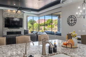 Kitchen featuring light stone counters, open floor plan, a fireplace, and a sink