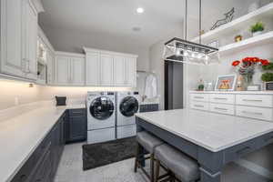 Laundry room featuring recessed lighting, cabinet space, and washer and dryer