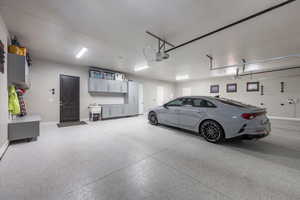 Garage featuring baseboards and a garage door opener