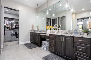 Full bath with visible vents, baseboards, a walk in closet, vanity, and recessed lighting