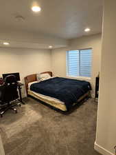 Bedroom with a textured ceiling, dark colored carpet, baseboards, and recessed lighting