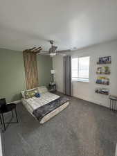 Bedroom featuring a textured ceiling, a ceiling fan, visible vents, baseboards, and dark colored carpet