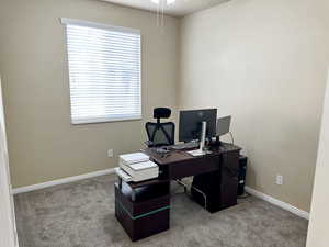 Carpeted office space with baseboards