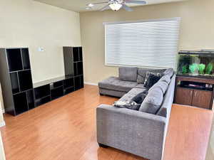 Living area featuring ceiling fan, wood finished floors, and baseboards