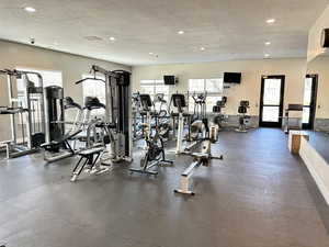 Workout area with a textured ceiling, baseboards, and recessed lighting