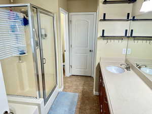 Full bathroom with toilet, a stall shower, tile patterned flooring, and vanity