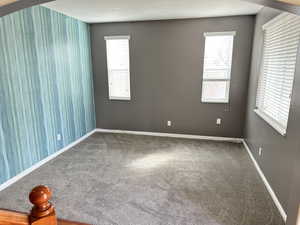 Unfurnished room featuring carpet floors and baseboards