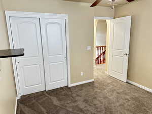 Unfurnished bedroom with arched walkways, a closet, carpet, and baseboards