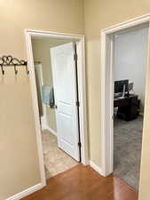 Corridor with light wood-style floors and baseboards