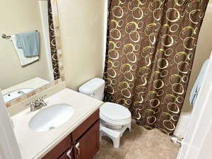 Bathroom with vanity, toilet, and tile patterned floors