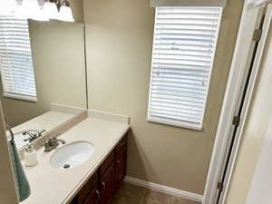 Bathroom with tile patterned floors, baseboards, and vanity