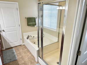 Full bathroom featuring a stall shower, tile patterned flooring, and a garden tub