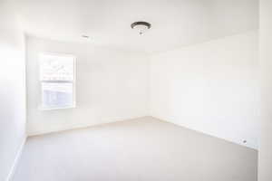 Unfurnished room featuring light carpet, visible vents, and baseboards