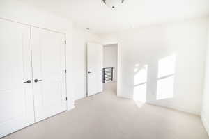 Unfurnished bedroom with baseboards, a closet, visible vents, and light colored carpet