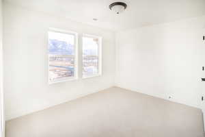 Carpeted spare room featuring visible vents, a mountain view, and baseboards