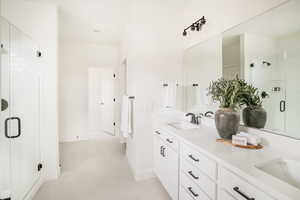 Full bathroom featuring tile patterned floors, a sink, a shower stall, and double vanity