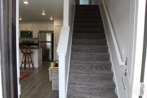 Stairs featuring recessed lighting and wood finished floors