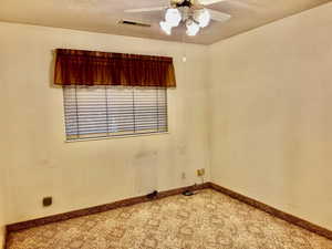 Spare room with baseboards, visible vents, and ceiling fan