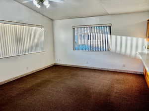 Empty room featuring a ceiling fan, baseboards, and carpet flooring