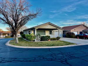 Ranch-style house featuring stucco siding, a porch, concrete driveway, a garage, and a front lawn