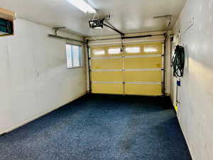 Garage featuring baseboards and a garage door opener