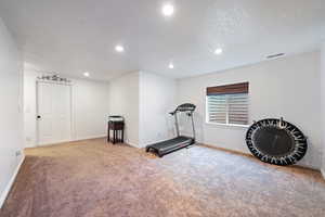 Workout room with carpet floors, recessed lighting, visible vents, and baseboards