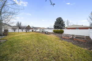 View of yard featuring a storage shed, an outdoor structure, a fenced backyard, and a garden