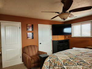 Bedroom featuring a textured ceiling, visible vents, and a ceiling fan