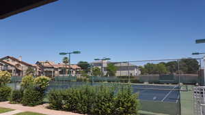 View of sport court featuring a residential view and fence