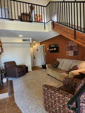 Living room featuring a towering ceiling and visible vents