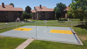 View of sport court with community basketball court, a lawn, and fence