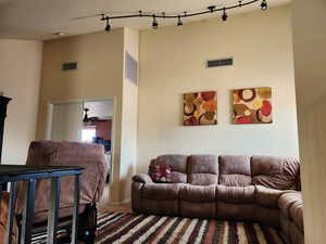 Carpeted living area featuring visible vents and a textured ceiling