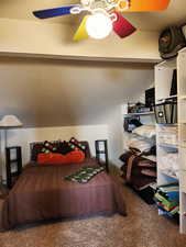 Bedroom featuring carpet, vaulted ceiling, and ceiling fan